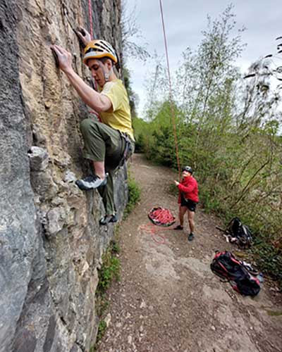 yellow-shirt-climbing Roped up Trainee in a yellow t short climbing